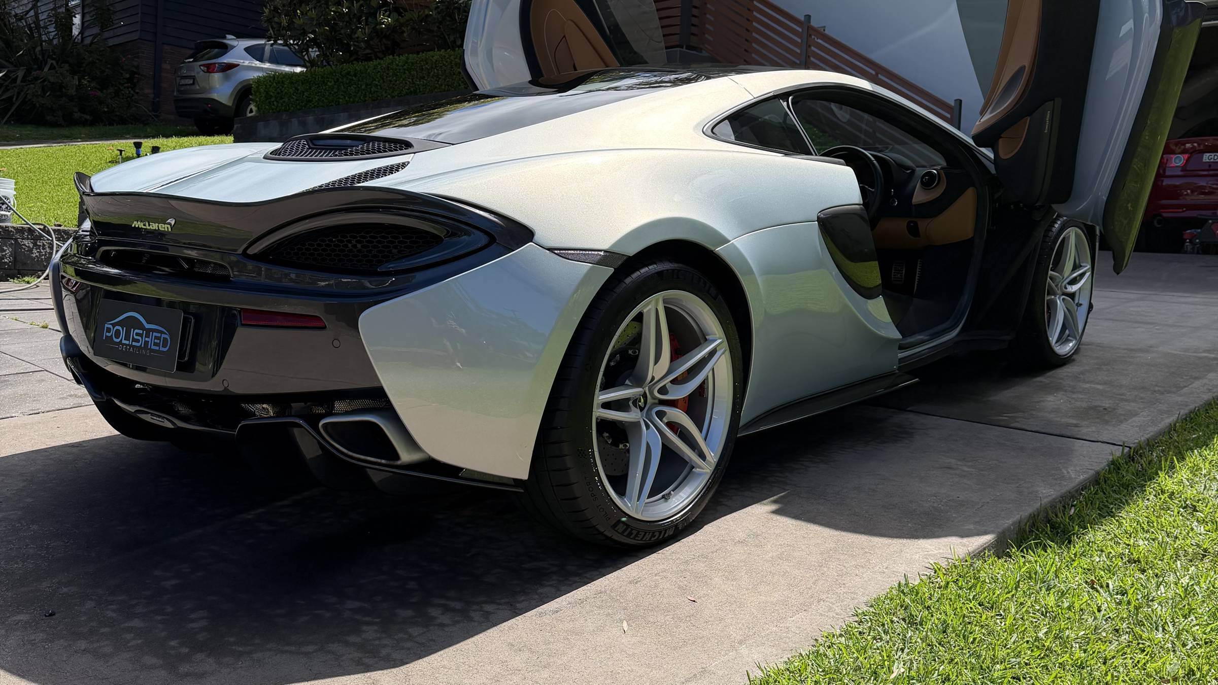 Silver McLaren 570S with its doors up after a detail by Polished Detailing